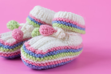 Baby's bootees on pink background. Close up