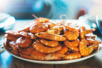 Isolated prepared orange shrimp on background table on kitchen, closeup of fresh prawn products in restaurant, shellfish sea food on plate, group cooked boiled seafood, ocean dieting shrimps