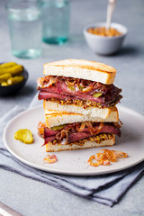 Roast beef sandwich on a plate with pickles. © annapustynnikova