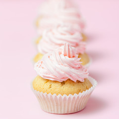 Cupcake decorated with pink buttercream on pastel pink background. Sweet beautiful cake. Square banner, greeting card for birthday, wedding, women's day. Close up photography. Selective focus