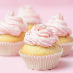 Cupcake decorated with pink buttercream on pastel pink background. Sweet beautiful cake. Square banner, greeting card for birthday, wedding, women's day. Close up photography. Selective focus