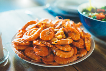 Isolated prepared orange shrimp on background table on kitchen, closeup of fresh prawn products in restaurant, shellfish sea food on plate, group cooked boiled seafood, ocean dieting shrimps