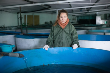 Female near fish tank on sturgeon farm