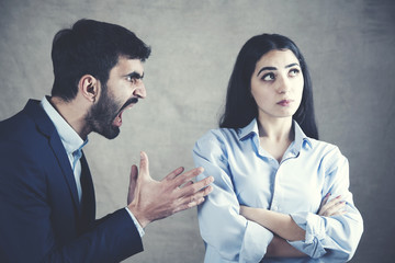 angry man and woman on dark background