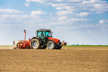 Farmer seeding, sowing crops at field. Sowing is the process of planting seeds in the ground as part of the early spring time agricultural activities.