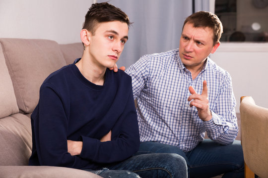 Adult man is asking forgiveness from his sad son after conflict