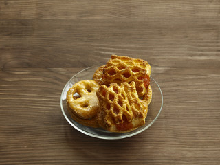 Homemade cookies on a transparent glass plate on a wooden table
