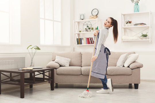 Happy woman cleaning home with mop and having fun