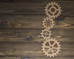Gears on a wooden background. Figures from natural wood. Copy space for design and text.