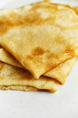 Macro shot of pancakes stacked in white plate
