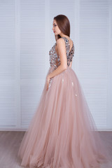 Fototapeta premium Beauty brunette model woman in evening dress. Beautiful fashion luxury makeup and hairstyle. Seductive girl silhouette in classic interior.