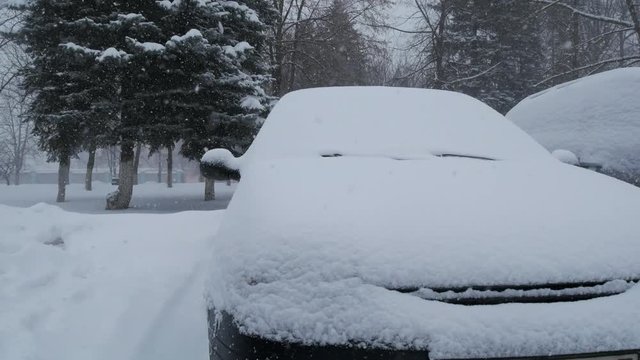 Car covered by snow, under severe winter storm.