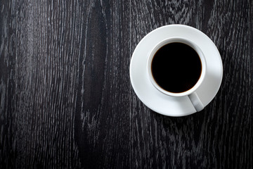White Cup of black hot coffee on dark wooden background