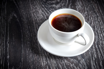 White Cup of black hot coffee on dark wooden background