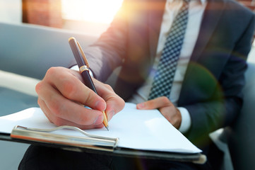 Businessman signs a contract. Holding pen in hand.