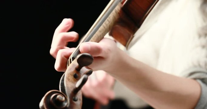 classical musician playing baroque violin on a black background - hands closeup live action concept