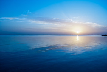 Winter sunrise on red sea. Blue sky and calm water on sunrise time. The cold sun morning. The sun under the sea blue water