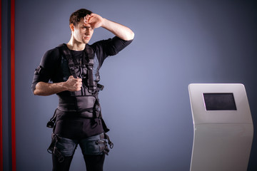 Tired sportsman wipes sweat after training with ems
