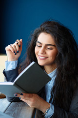 Woman sitting in coffee shop and writing notes