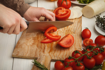 Woman's hand cutting fresh tomatoes
