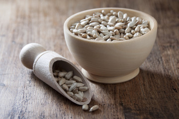 Sunflower seeds in a wooden bowl and a wooden spoon