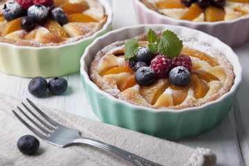 Tarts with curd cream, apricot and berries in ceramic form