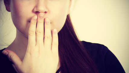 Woman covering her mouth with hand