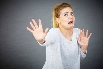 Scared woman gesturing stop gesture with hands