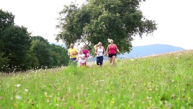 Family, mother, father and kids running for sport over a meadow