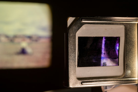 Vintage Photo Slides Projector Showing Old Photographs Slides In Dark Room