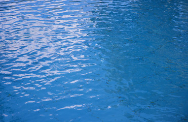 Fototapeta na wymiar Blue water surface background. Rippled water texture. Swimming pool surface