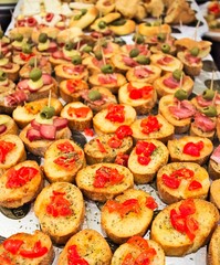 aperitif buffet with appetizers and bruschetta with tomatoes, olives, sauces and salami