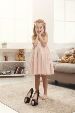 Little fashionista trying on her mom`s shoes