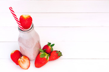 Strawberry milkshake on a white wooden background (copy space)