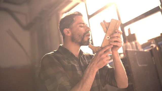 Handsome man in his fourties working with tools and wood at his workplace