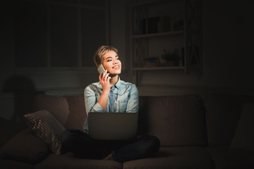 Happy woman with laptop at dark home office copy space