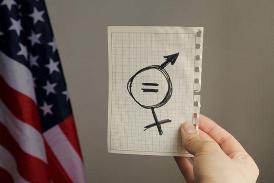 equals sign and a male symbol drawn on a piece of paper depicting the women sexual equality. gender equality drawn in it. fairness of treatment for women and men in the USA flag