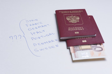 Russian passport with euro banknotes on a white sheet with inscriptions of European countries. Planning your trip on vacation.