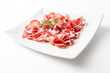 Prosciutto. Curled slices of delicious italian prosciutto with rosemary