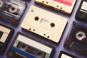Vintage audio cassettes on violet background, closeup