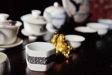 Obraz na płótnie Canvas Dishes for the tea ceremony and the figure Hotei on the tea table.