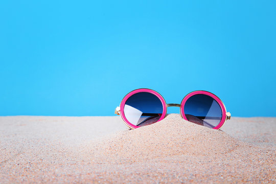 Pink sunglasses on the beach sand