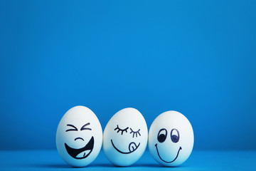 Eggs with funny faces on blue background