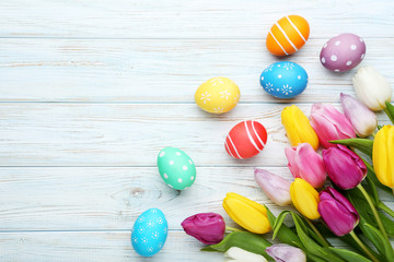 Colorful easter eggs with tulips on wooden table