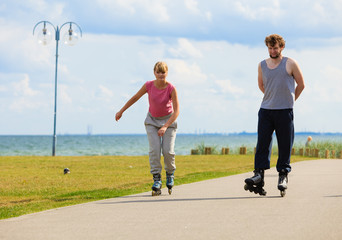 Youngsters together skating in seafront park.