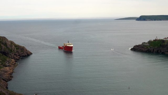 Large red boat entering St Johns Harbor at Newfoundland Canada