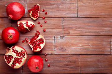 Ripe and juicy pomegranate on brown wooden table