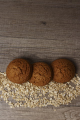 three oatmeal cookies lie on a black plate