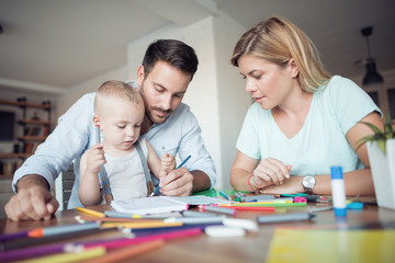 Fototapeta premium Mom, dad and son draw in the living room.