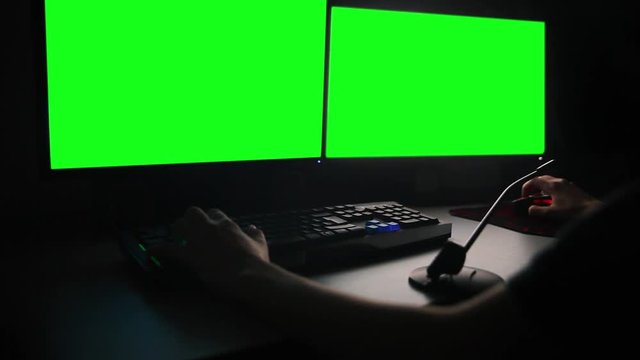 working with two monitors in dark, green screen